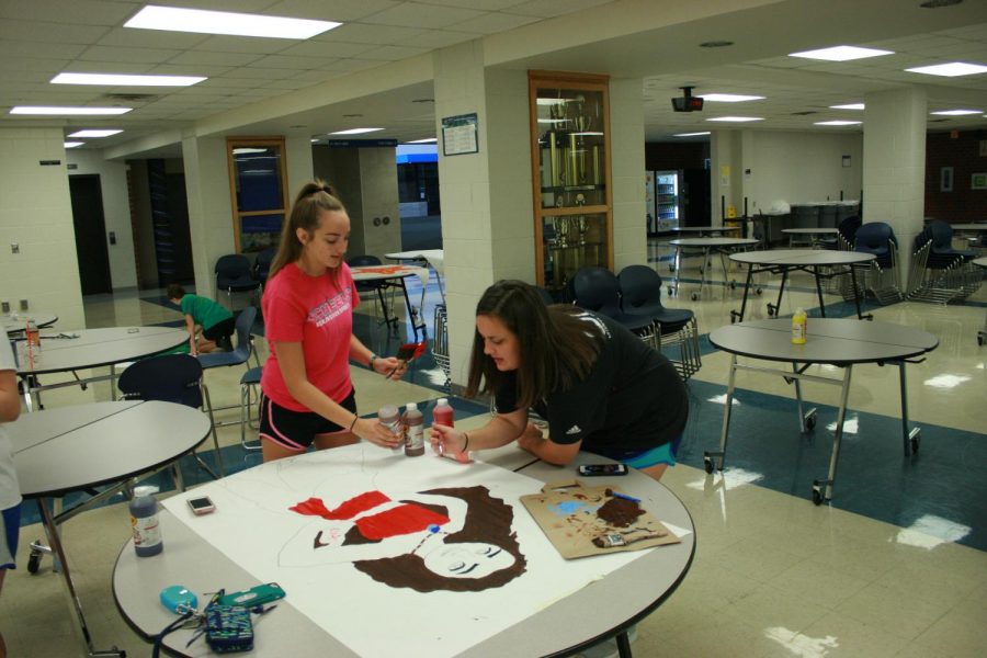 sophomores+Emma+Gibbs+and+Alexa+Preister+work+to+create+Disney+character+decorations.+Student+Council+members+work+past+midnight+to+decorate+the+night+before+the+dance.