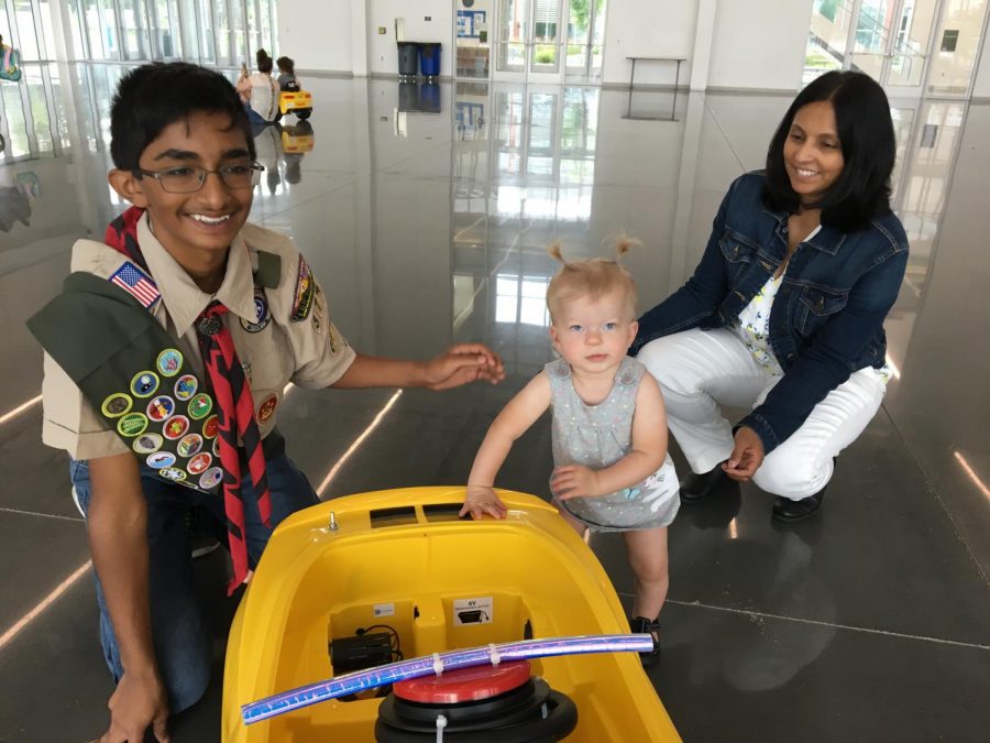 Fichadia poses with a toddler who has just reached her redesigned race car