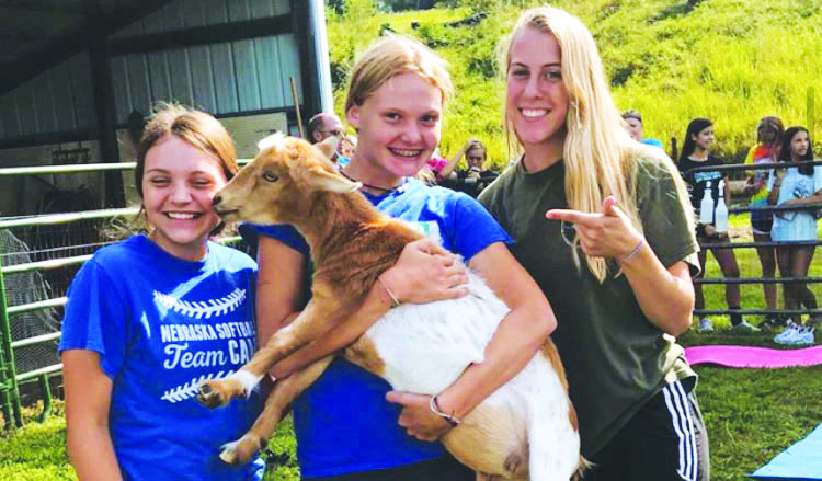 (from left to right) Sophomores Helena Kegley, Alyssa Stalzer, and Addison Haas cradle a goat after completing their goat yoga team bonding activity at JAMS Goat Yoga. 
I had so much fun with all the goats. I loved when they climbed on our backs and when we could pick them up and give them treats.