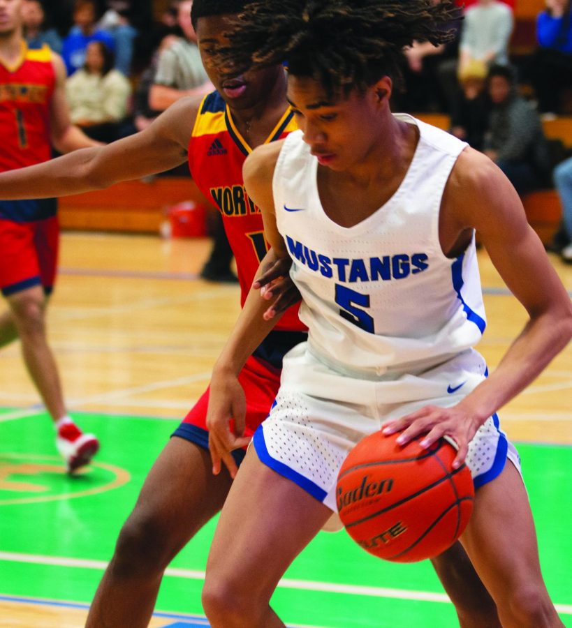 Junior Hunter Sallis blocks an Omaha Northwest player while dribbling during a Friday, Feb. 8 game. Sallis contributed to their 63-53