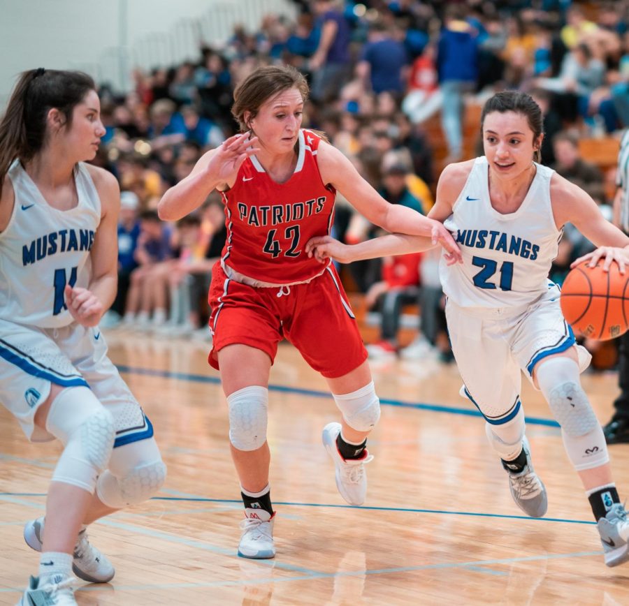 Senior Nicole Avila-Ambrosi takes the ball down the court while defending against a Millard South Patriot. the Mustangs took on their rivals, the Patriots, at the Stable on Jan. 31st. 