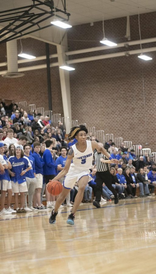 Junior guard, Hunter Sallis dribbles the ball past the defense. Millard North went on to defeat the Lincoln Southeast Knights 78-61.