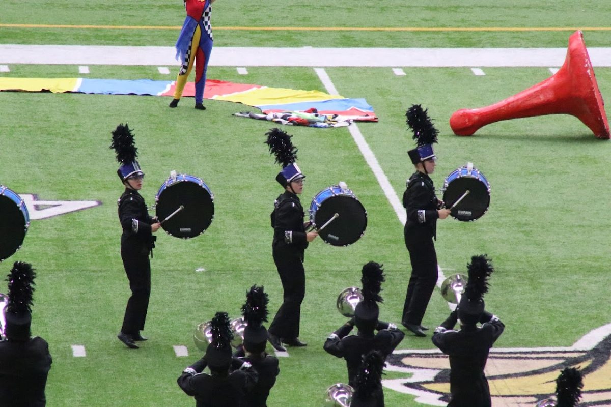 Drumline members, freshman Bailey Wolfe and seniors Josslyn Morgan and Anastasia Branson march uniformly in a line at the Youth in Music competition. “I had a wonderful time [at the competition] hanging out with my drumline, watching other shows, and getting to know my instrument better,” Wolfe said. 