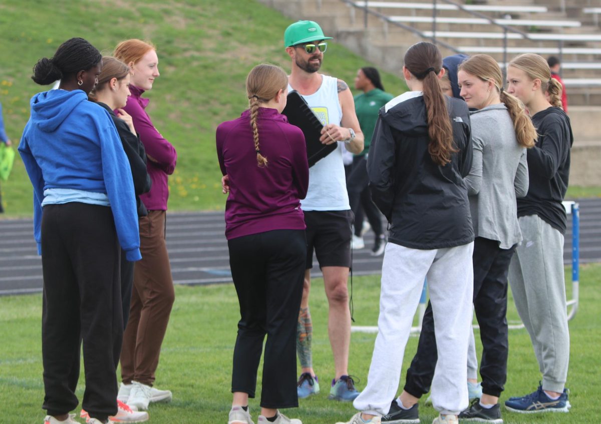Coach Stew tells the Girls Distance Track Team their run for the day. Stew schedules runs to help the girls do their best. 