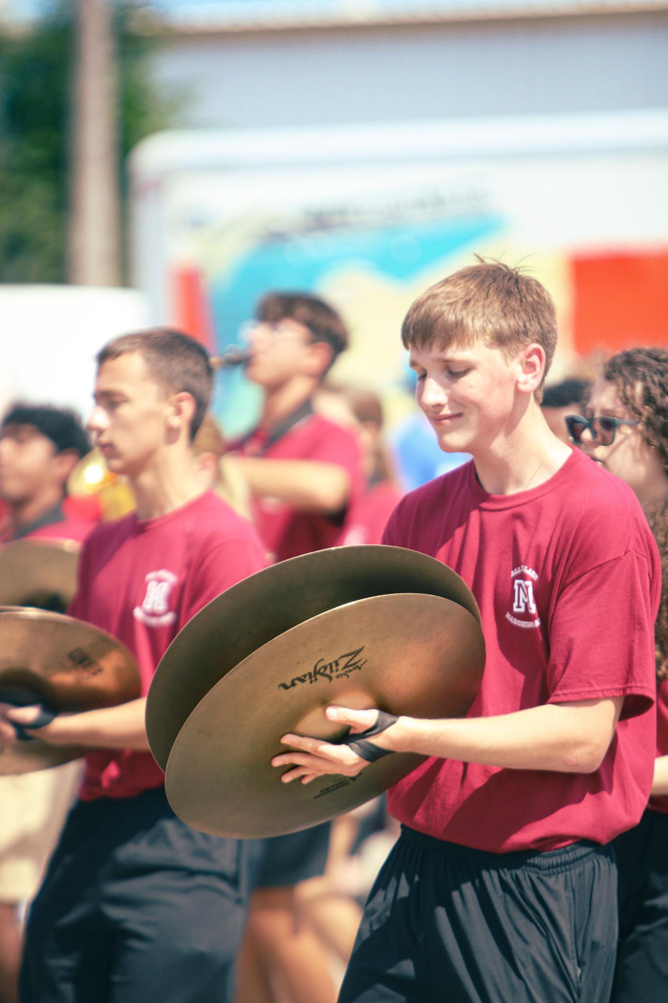 Senior Bret Selman plays his cymbals during the band's performance at Millard Days. The band members are dressed in the same uniform to signify their unity as one. 