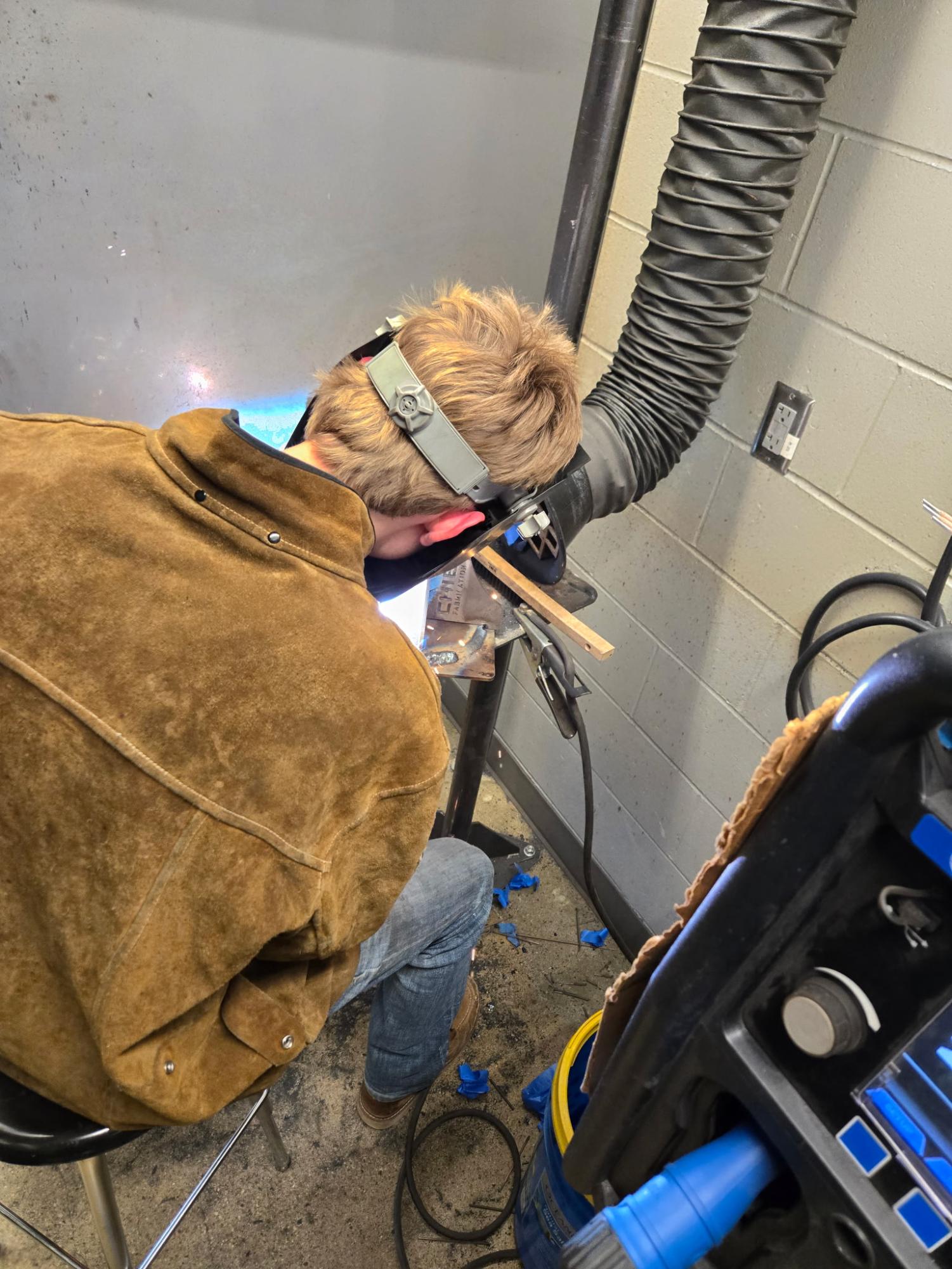 During the competition, sophomore Rex Weaver had to complete two sections to test his full understanding of welding: A test and and a project. The test, pictured to the right, consisted of 25 questions, with a minute to answer each question. The project challenged Weaver to weld four triangular pillars to a flat and circular metal base, pictured left. The process Weaver used is referred to as stick welding, which utilizes electricity to bond a metal rod (stick) to the base metal. He is pictured above applying this method.